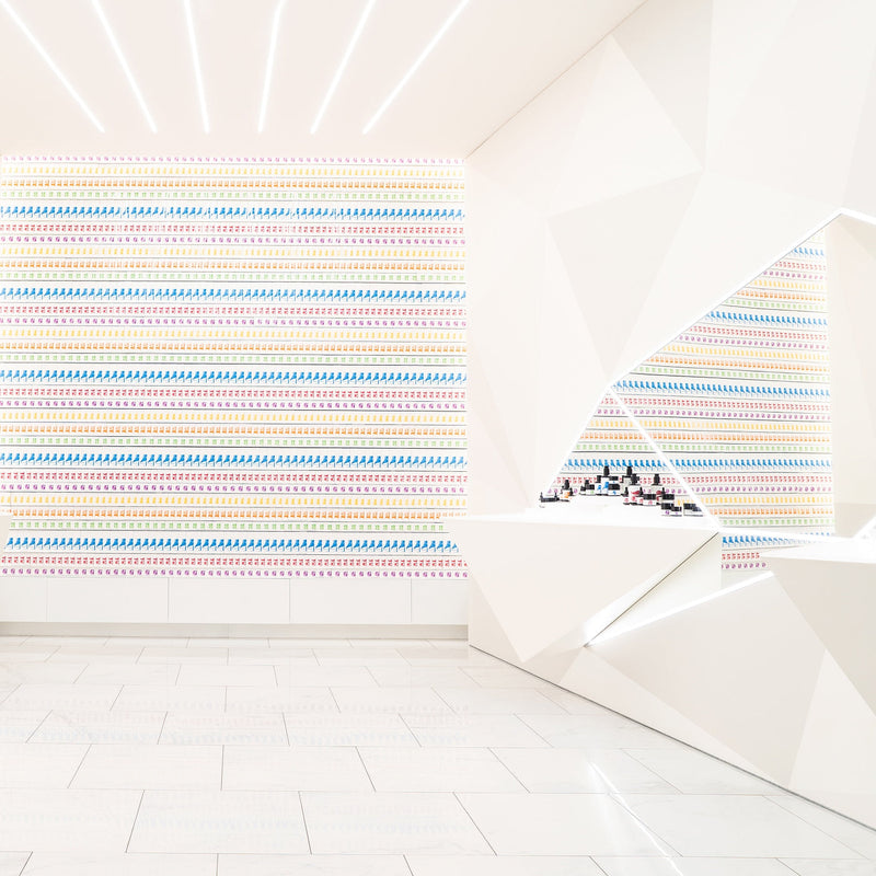 Colorful striped pattern on a white wall with geometric shapes.