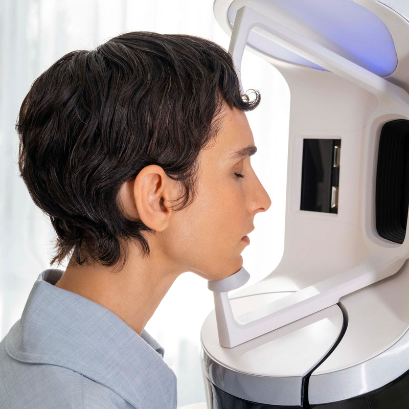 Person undergoing a facial scanning or analysis device on a white background