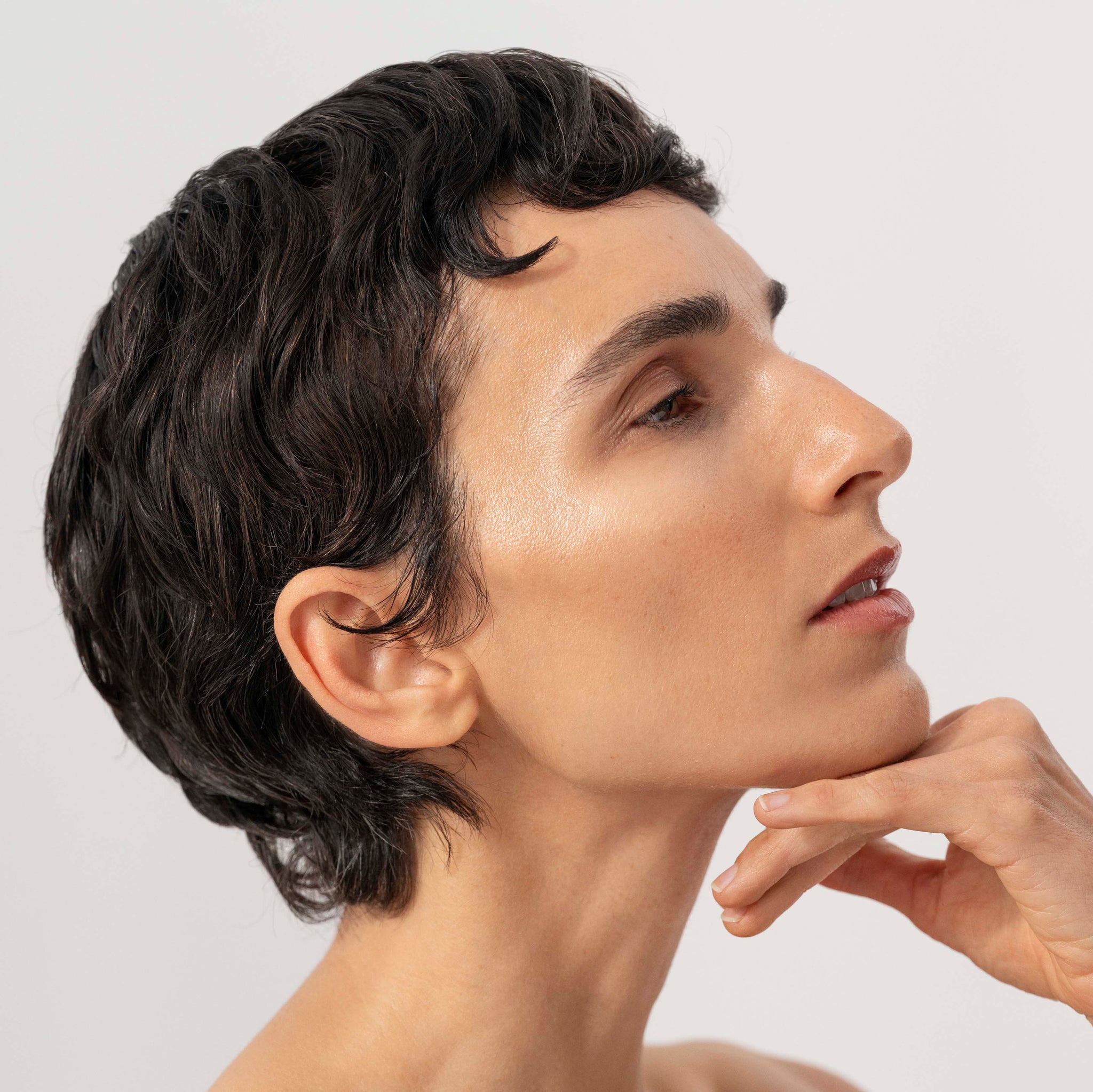 Woman with short black hair against a light background