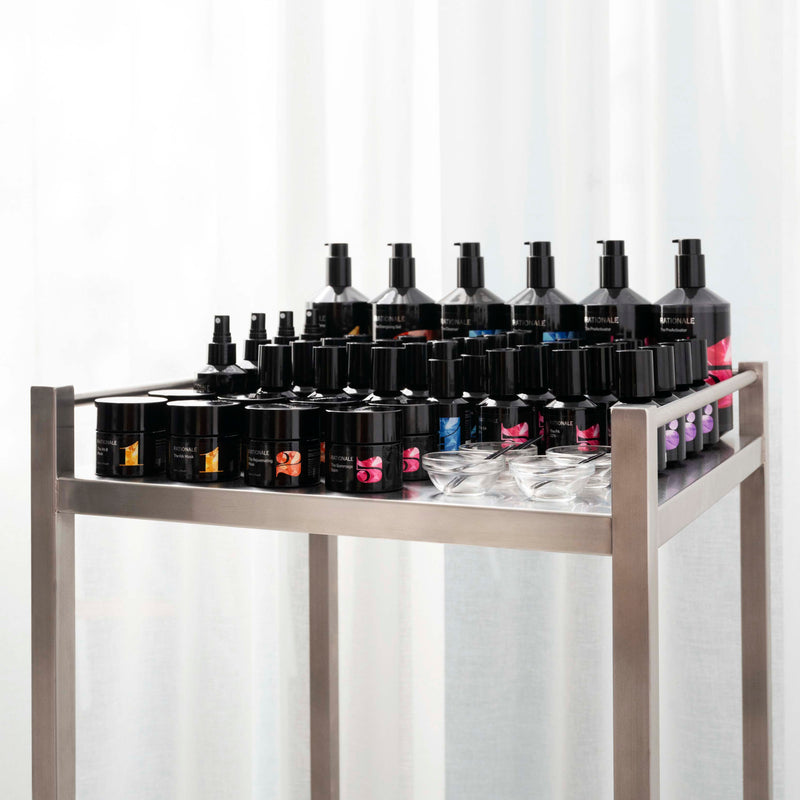 Display of various bottles and containers on a metal rack against a white background