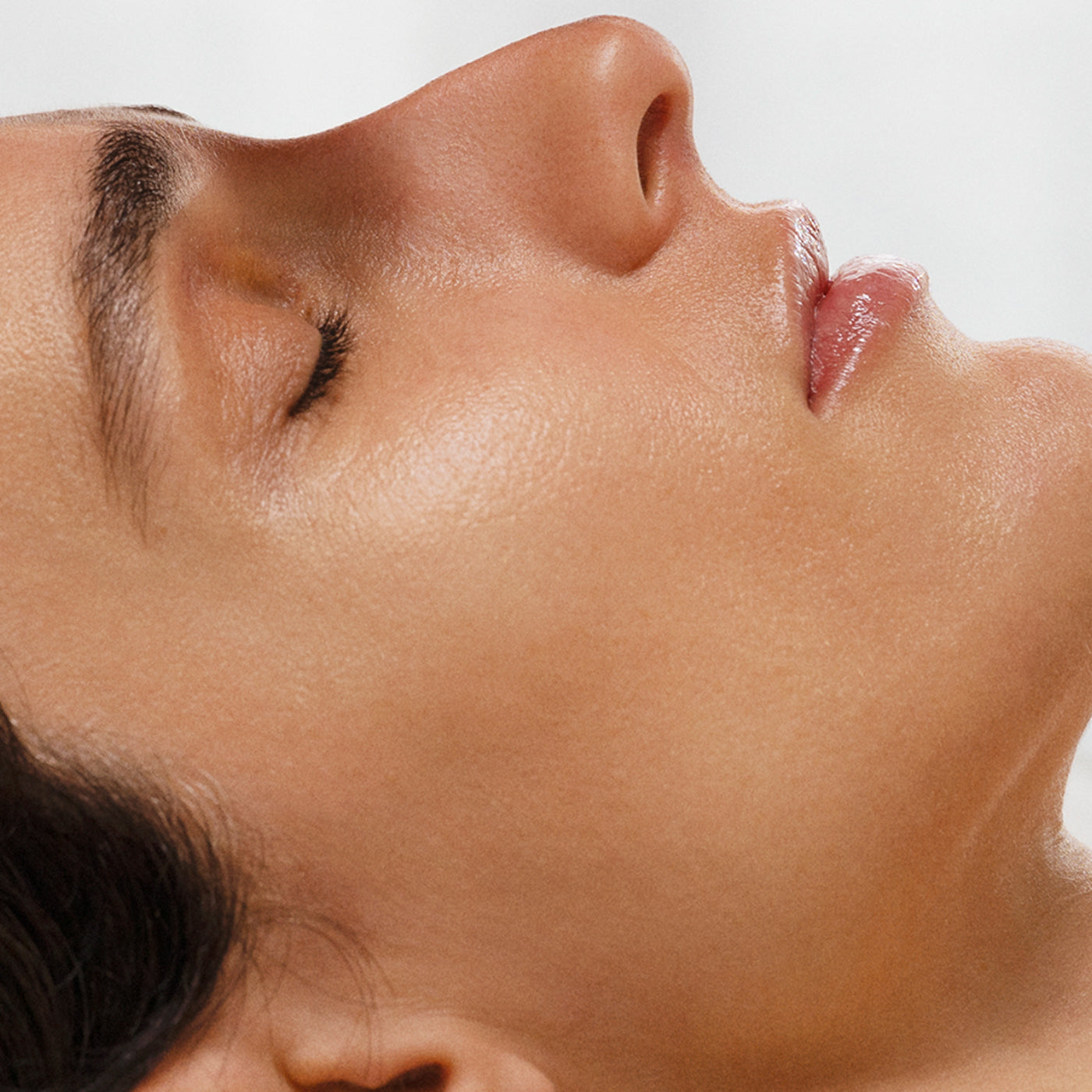 Close-up of a person's neck and jawline with a neutral background