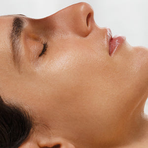Close-up of a person's neck and jawline with a neutral background